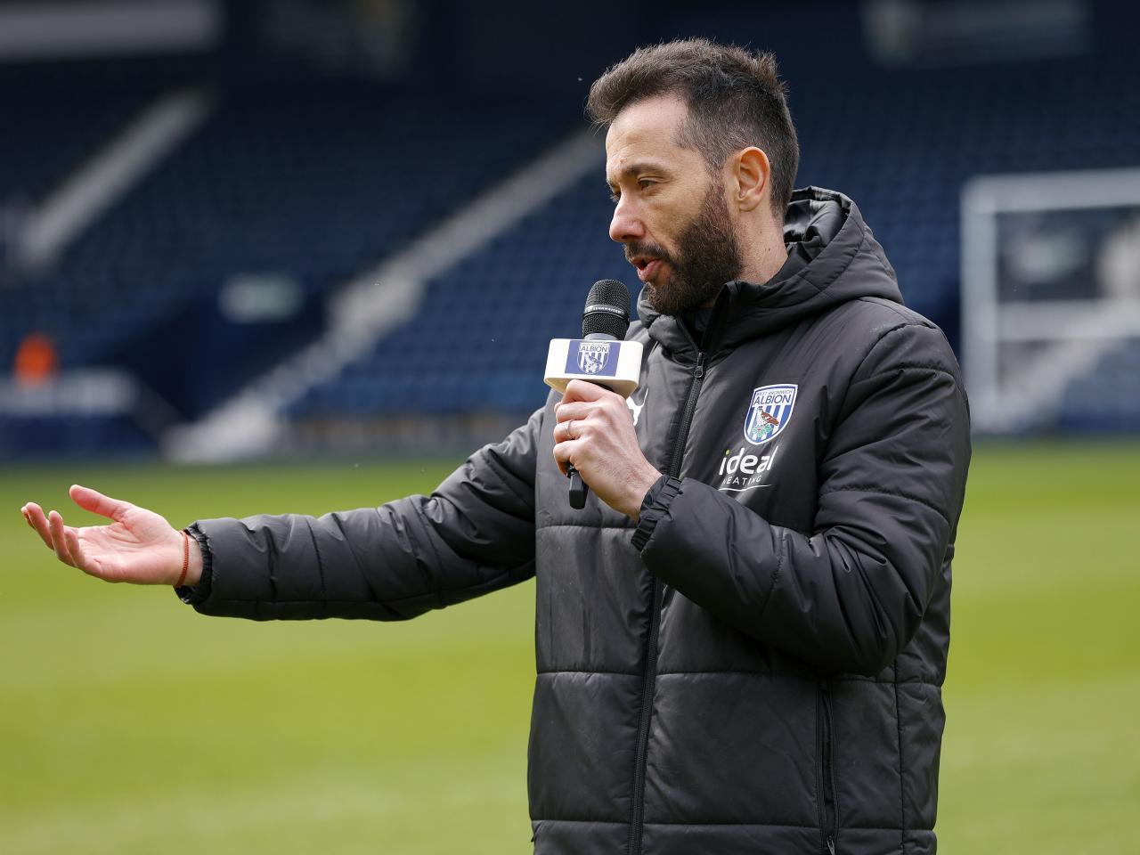 Carlos Corberán holding a mic talking to supporters at The Hawthorns