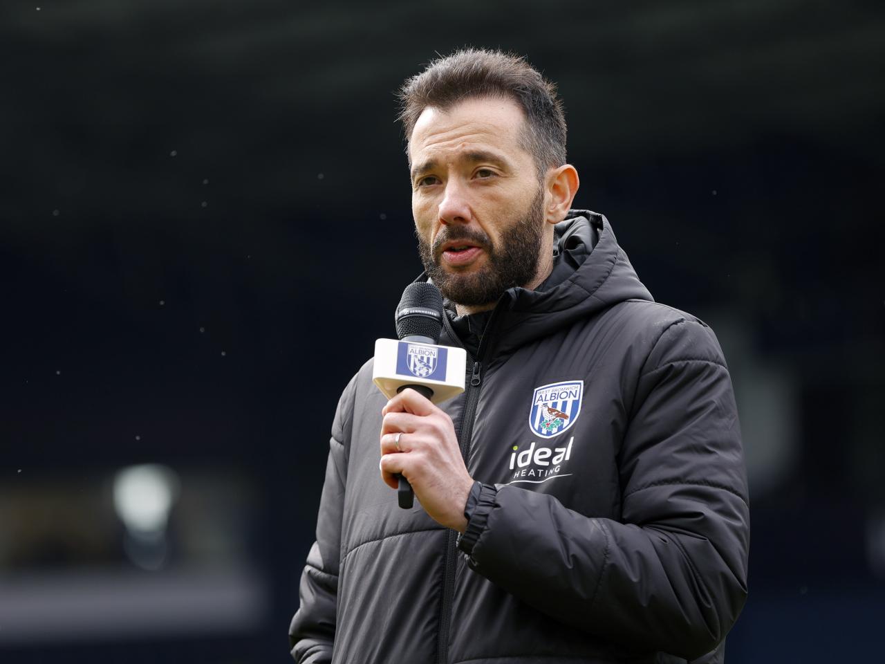Carlos Corberán holding a mic talking to supporters at The Hawthorns