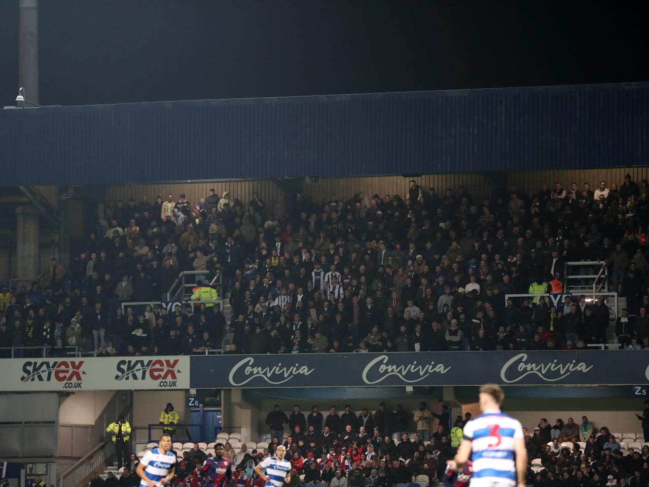 A general view of Albion fans in the top tier of the stand behind the goal at Loftus Road 
