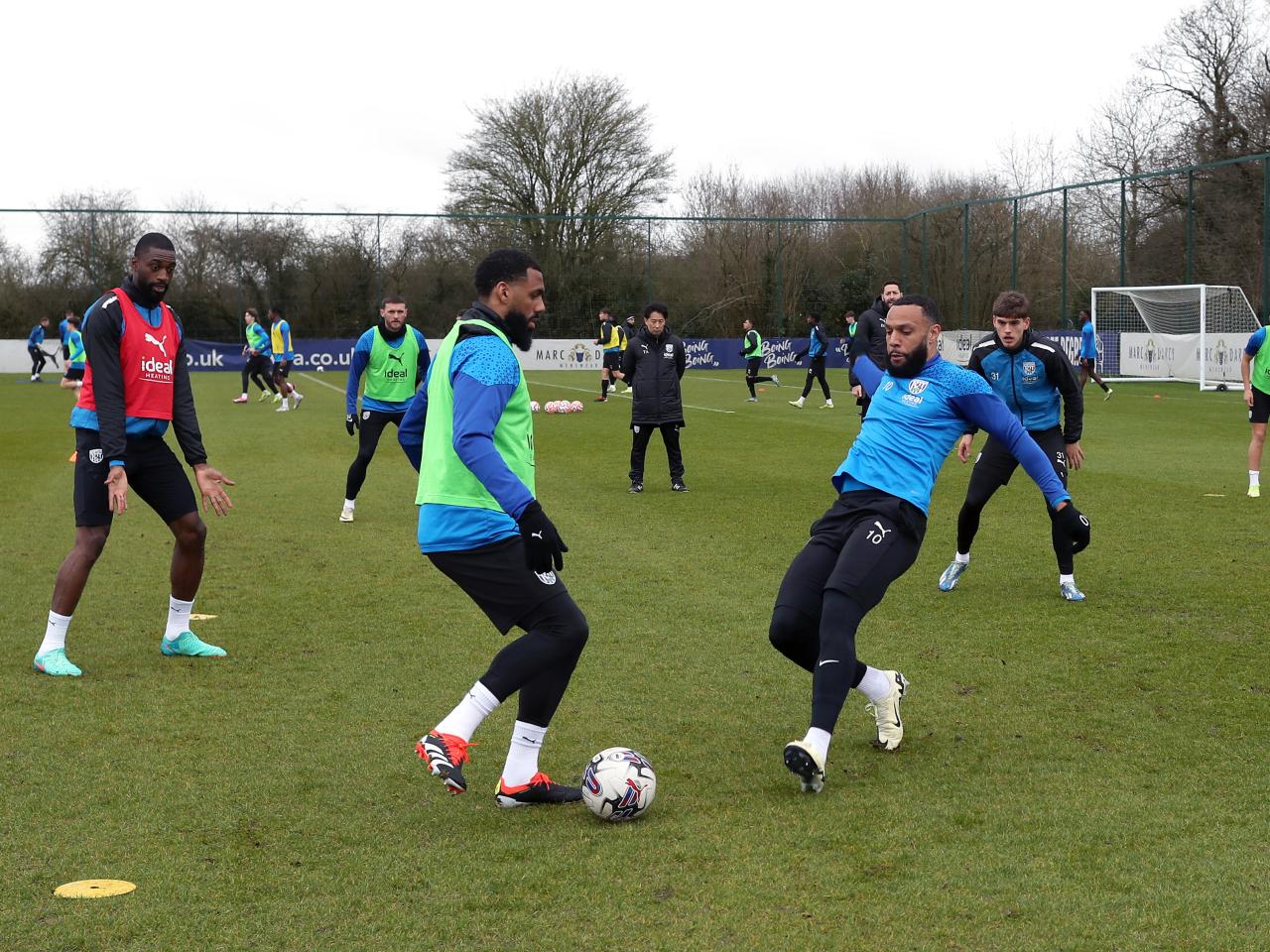 Yann M'Vila makes a pass in training with Matty Phillips closing him down