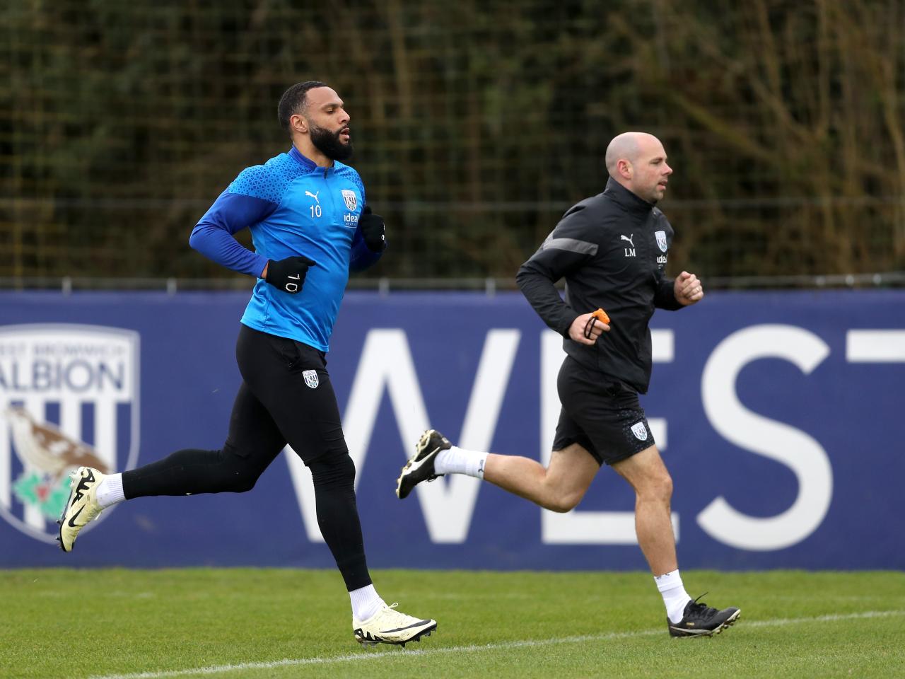 Matty Phillips running with a fitness coach during a training session