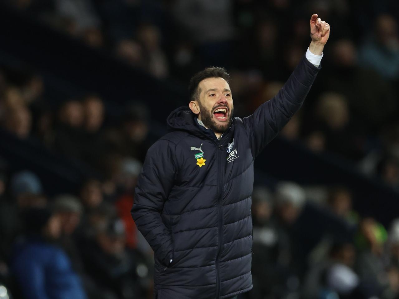 Carlos Corberán with his arm in the air on the touchline against Coventry 