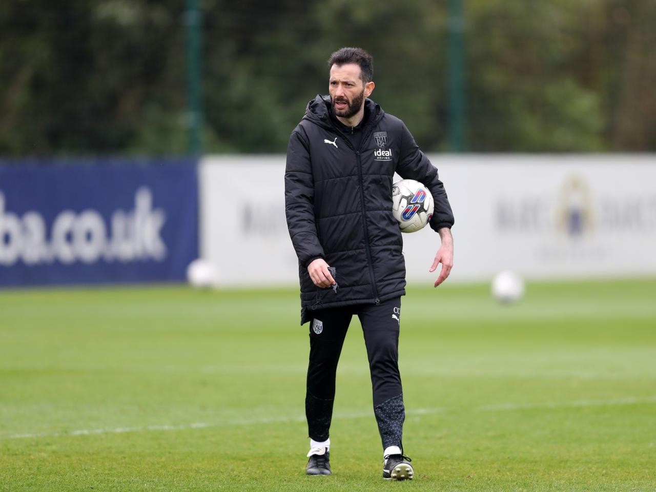 Carlos Corberán holding a football during a training session
