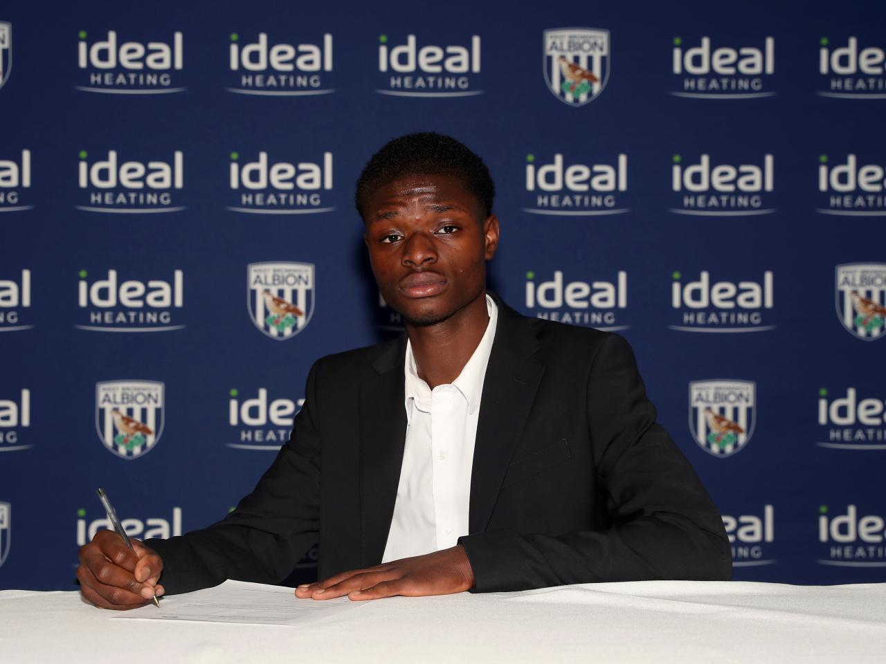 A photo of Abdul Abudu signing his scholarship deal