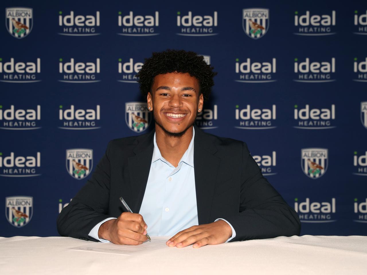 A photo of Adam Okorodudu signing his scholarship deal