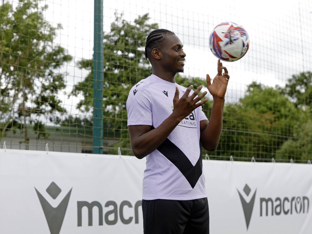 Ousmane Diakité smiling while juggling a football