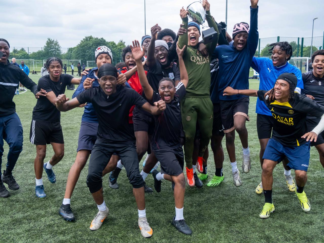 Winning team (Non bibs) jumping for joy with the winners trophy.