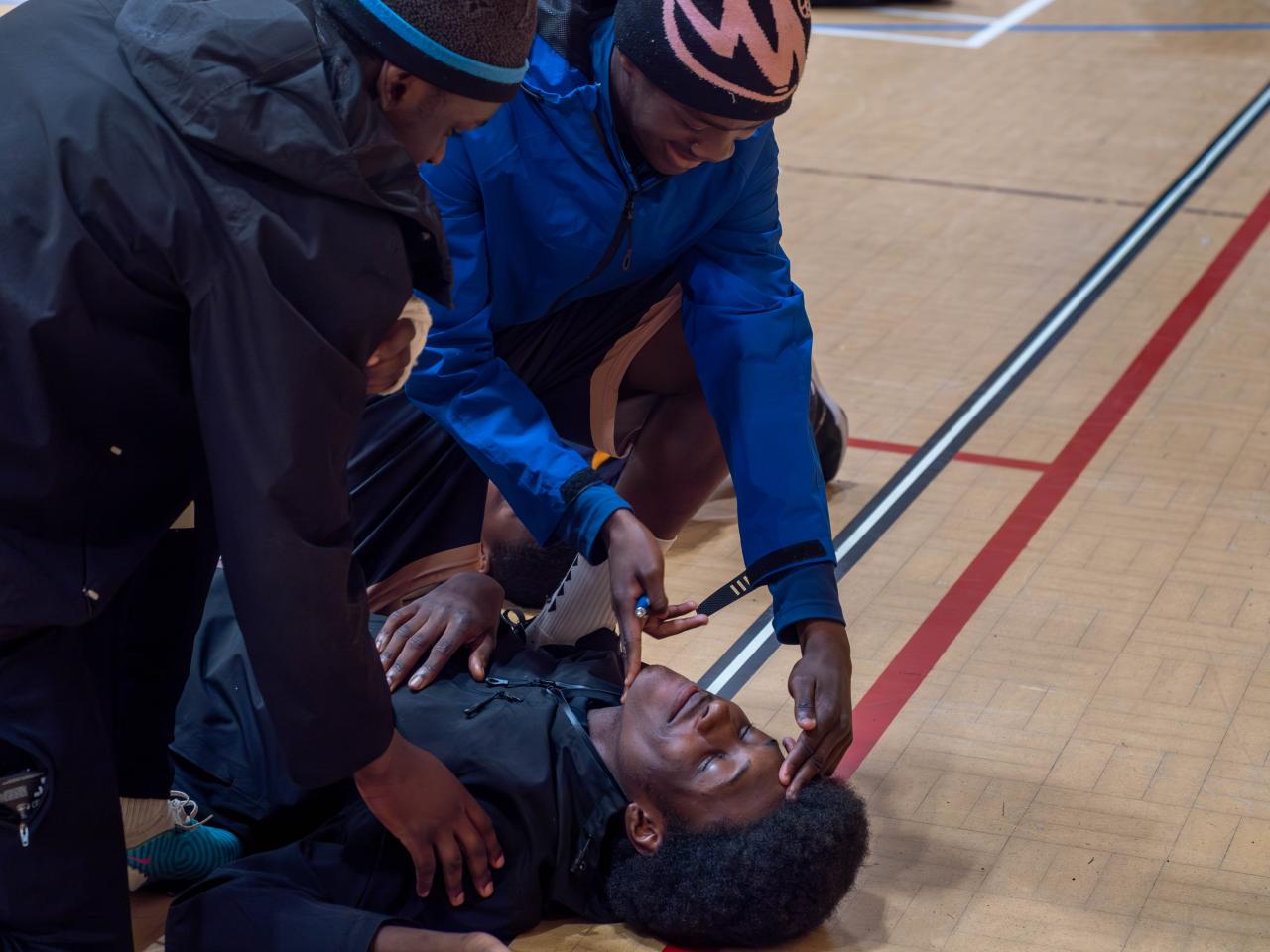 Two participants checking airway on another participant.