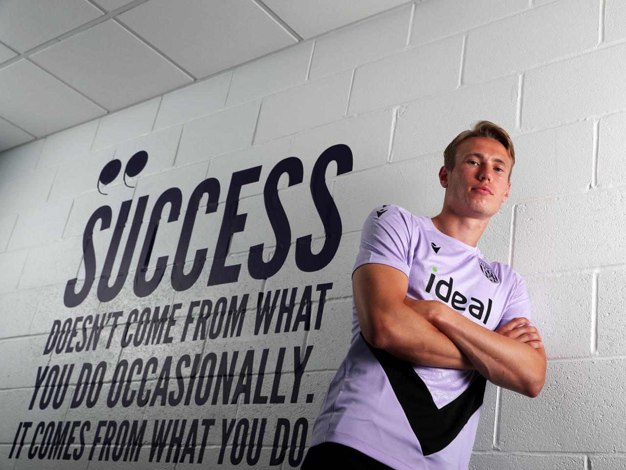 Torbjørn Heggem stood next to a wall with motivational words