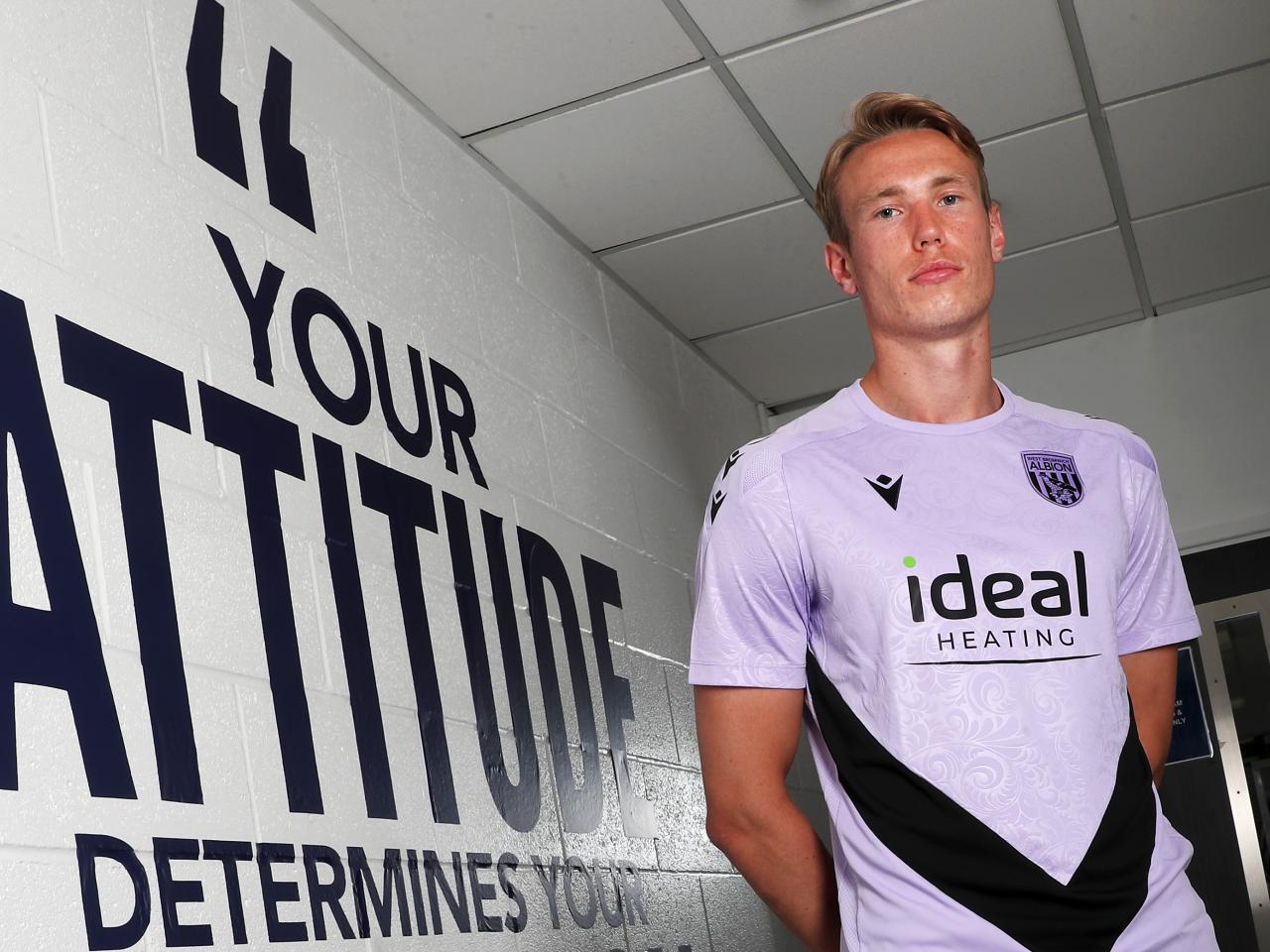 Torbjørn Heggem stood next to a wall with motivational words