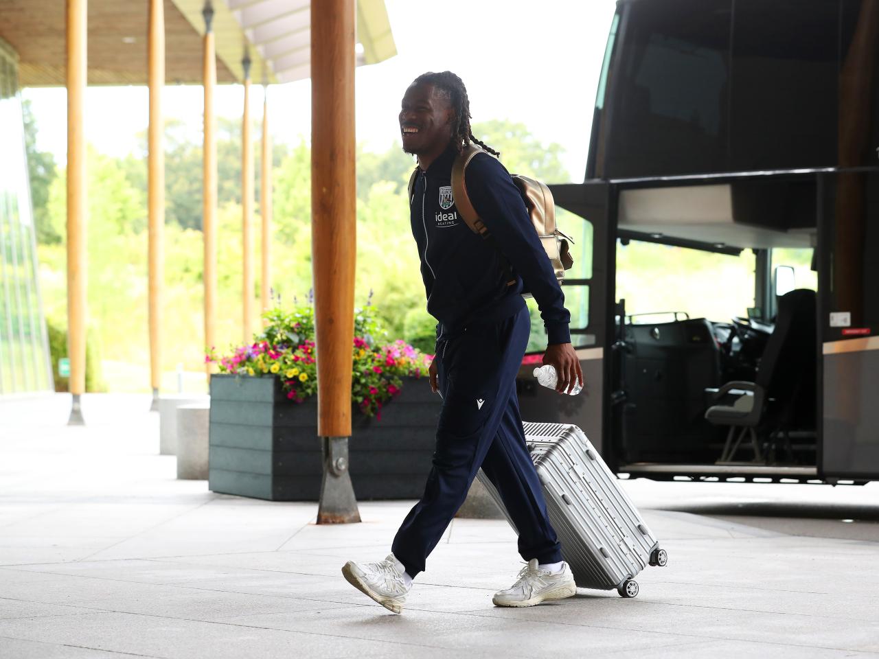 Brandon Thomas-Asante arriving at St. George's Park pushing a suitcase 