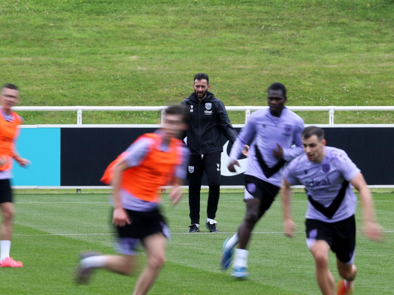 Carlos Corberán out on the training pitch at St. George's Park watching the session