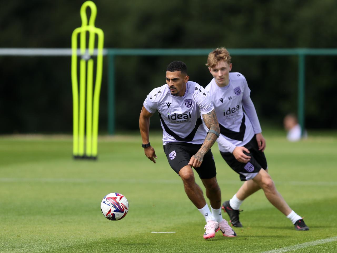 Karlan Grant on the ball during training being chased by Ollie Bostock 