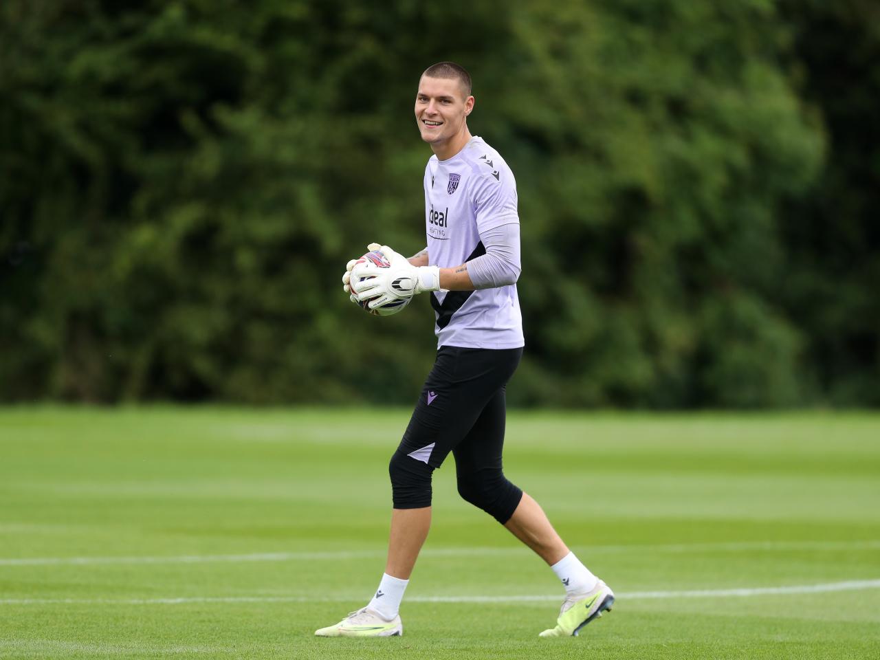 Ted Cann smiling while gripping the ball during a training session 