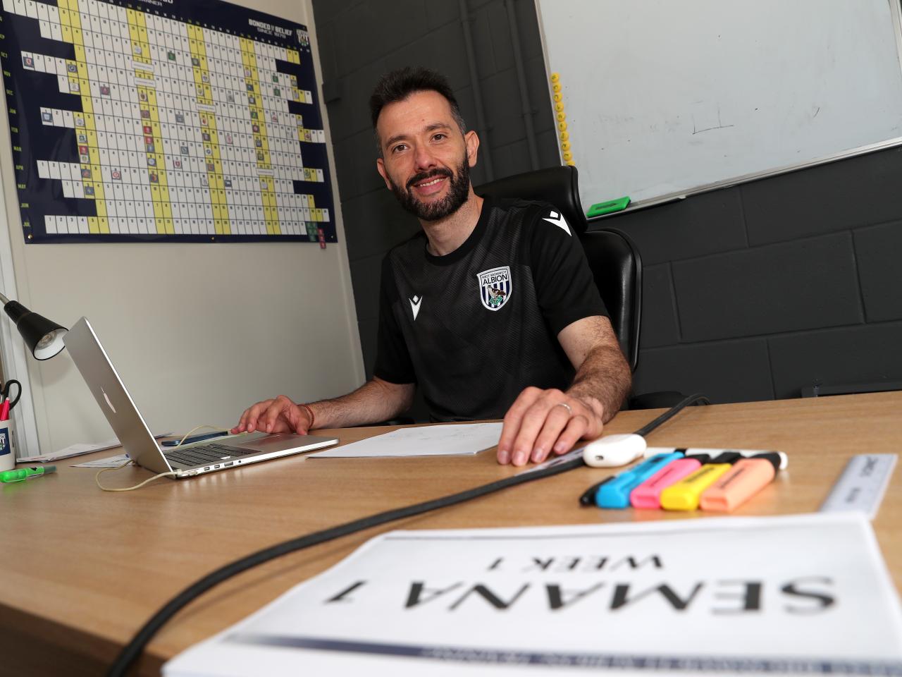 Carlos Corberán smiling at the camera while sat in his office at the training ground 