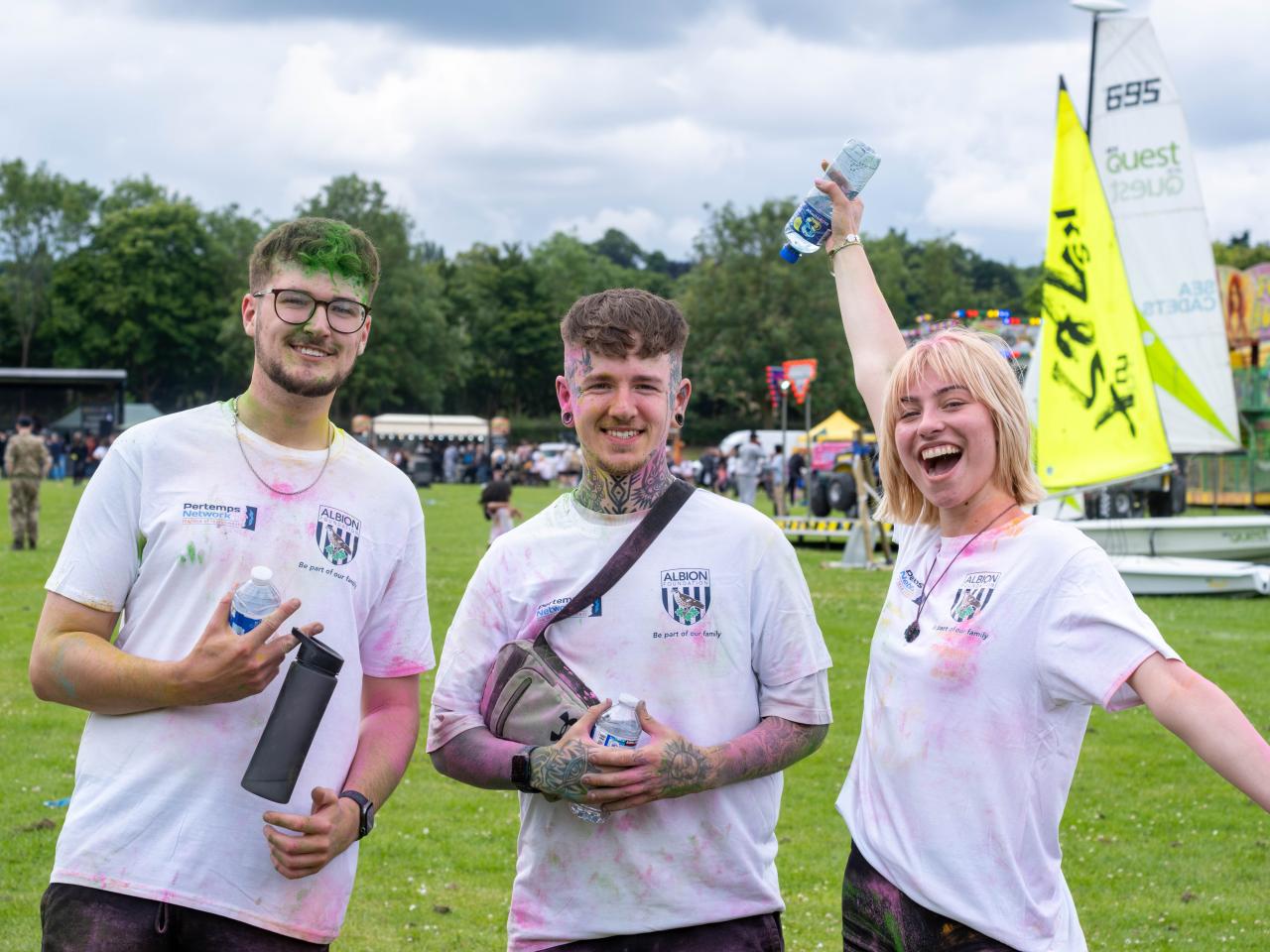 Three particpants posing for photo, girl on the right with arms spread out wide.