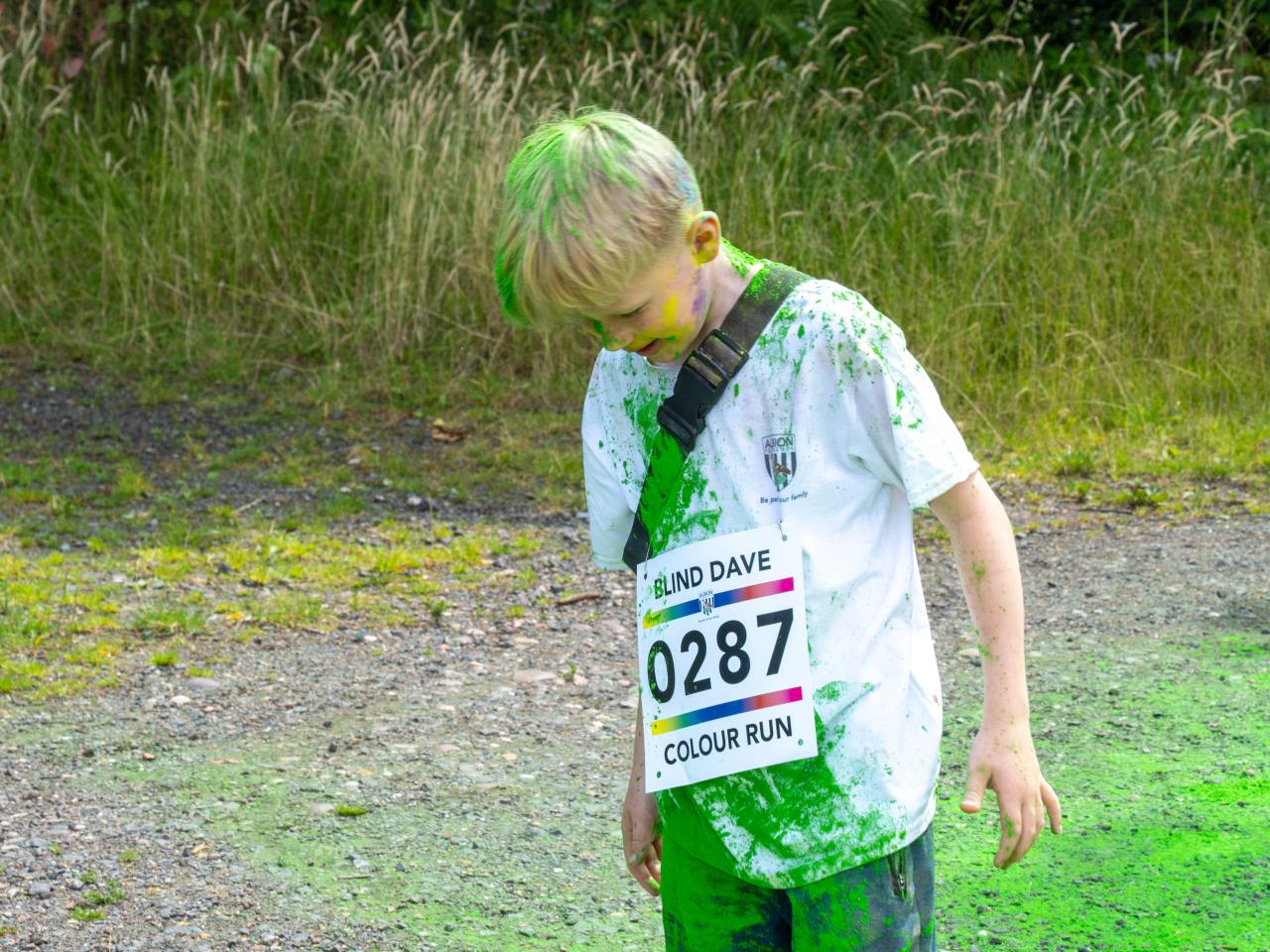Young participant shaking powder out of his hair.