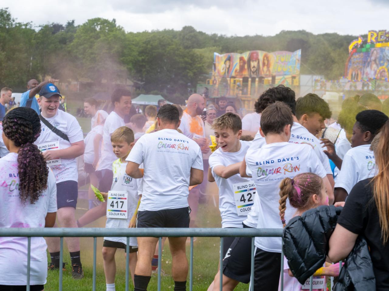 Group of participants inside barrier throwing paint powder.