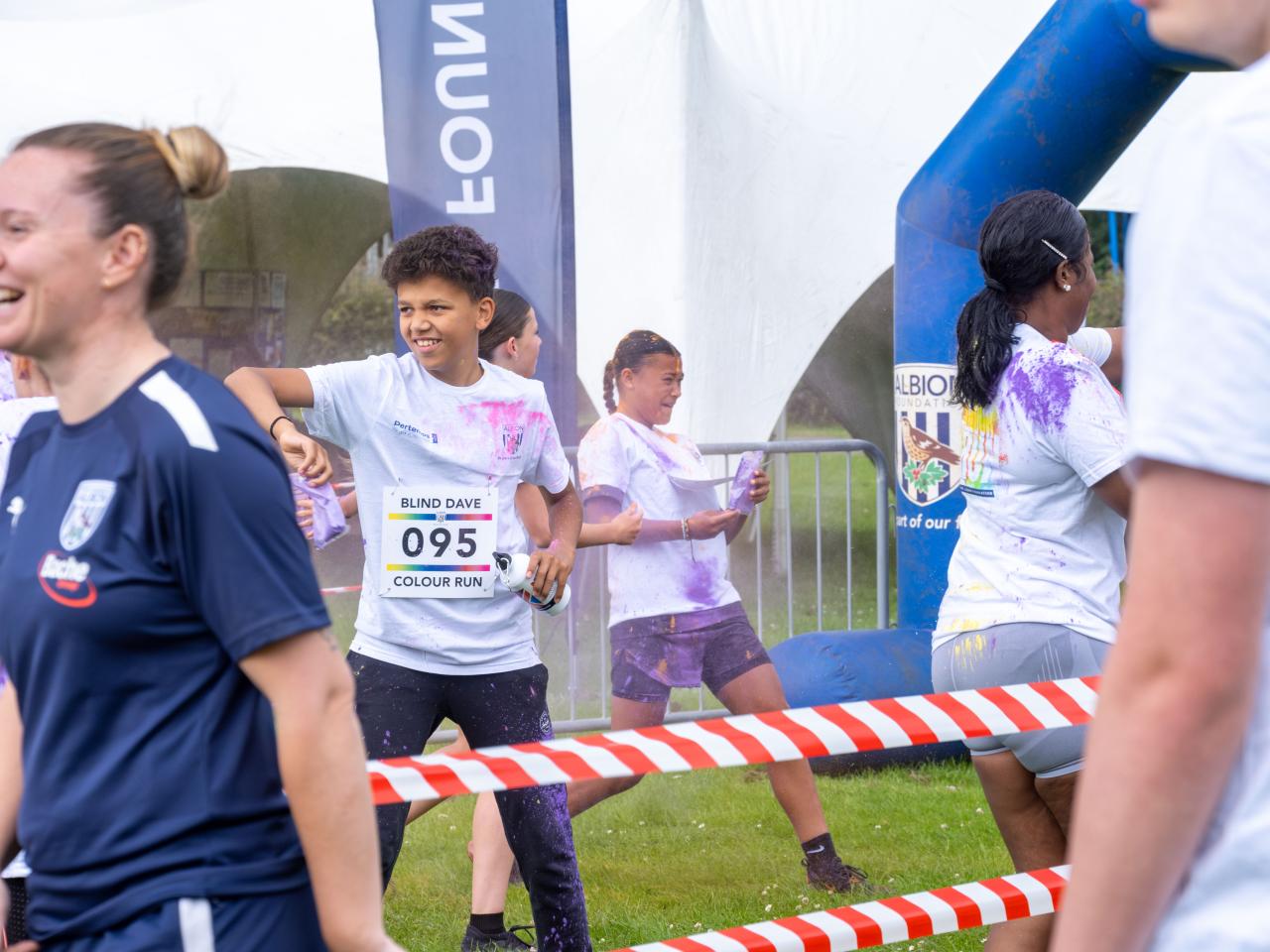 Group of participants inside barrier throwing paint powder.