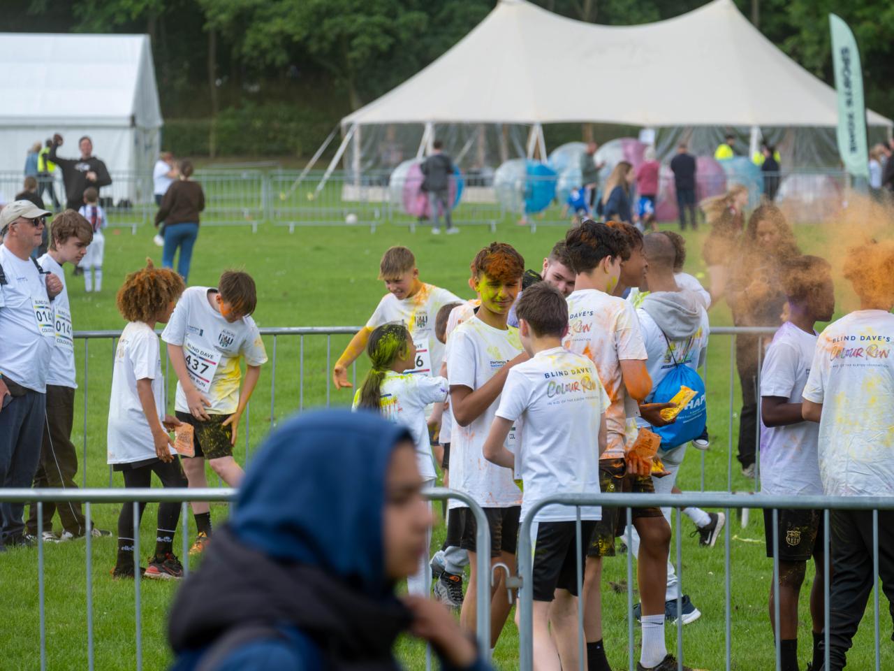 Group of participants inside barrier throwing paint powder.
