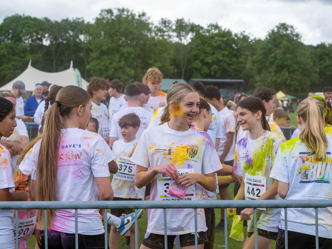 Group of ETC participants inside barrier throwing paint powder.