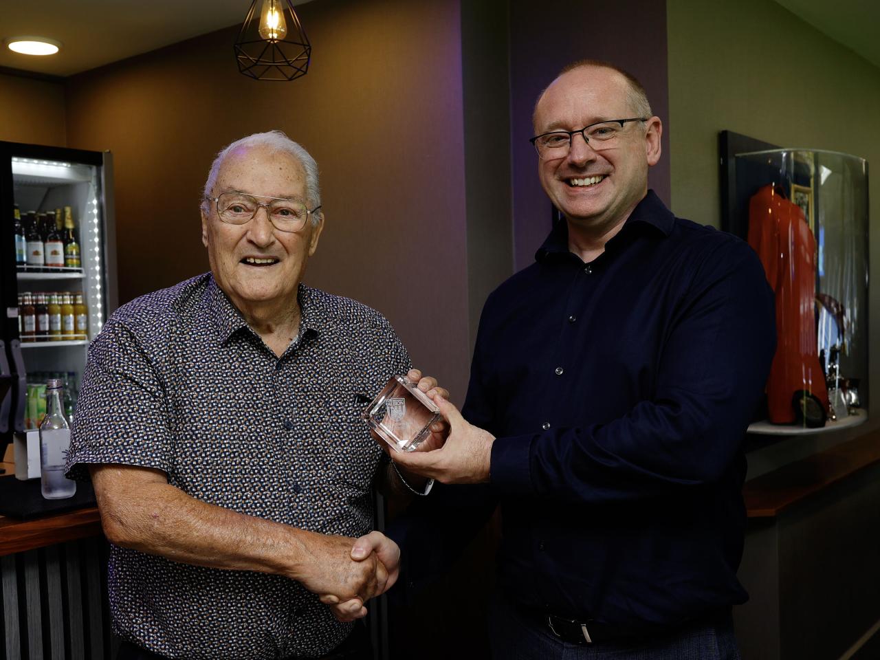 Graham Williams shaking hands with Mark Miles inside the Graham Williams Suite 
