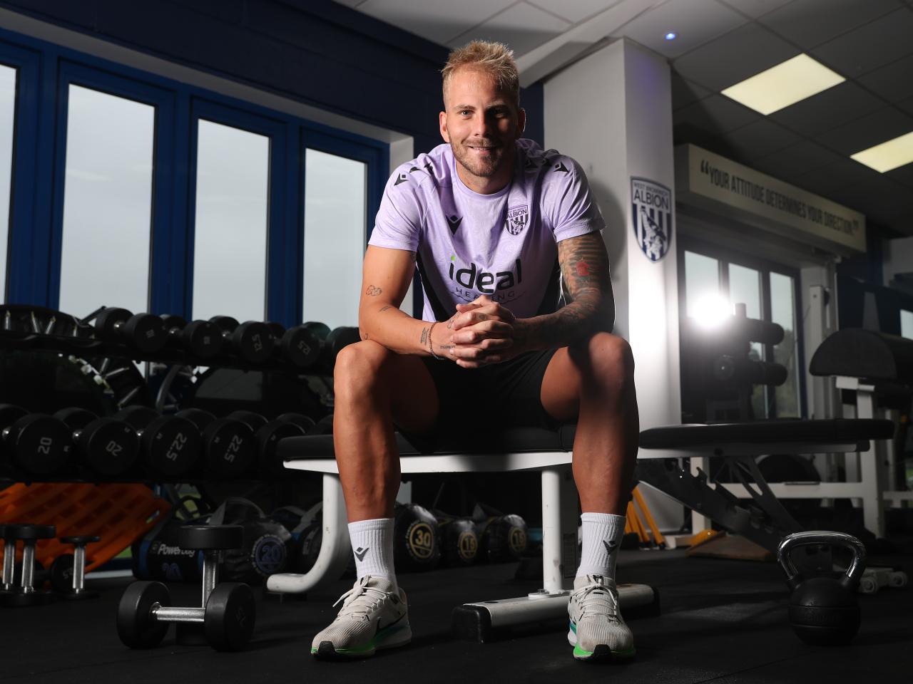 Uroš Račić smiling at the camera while sat in gym 