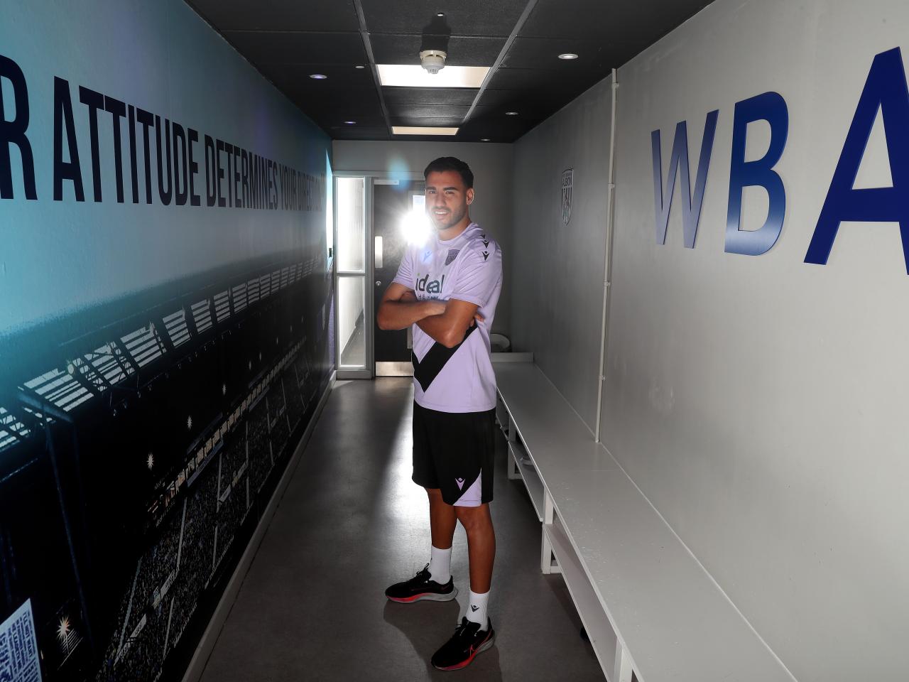 Gianluca Frabotta smiling at the camera while stood in a corridor 