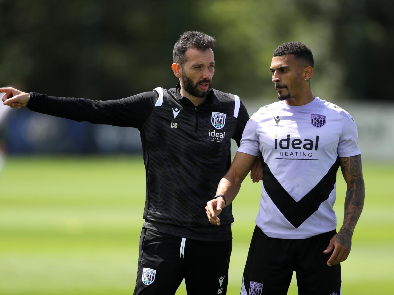 Carlos Corberán giving instructions to Karlan Grant during a training session 