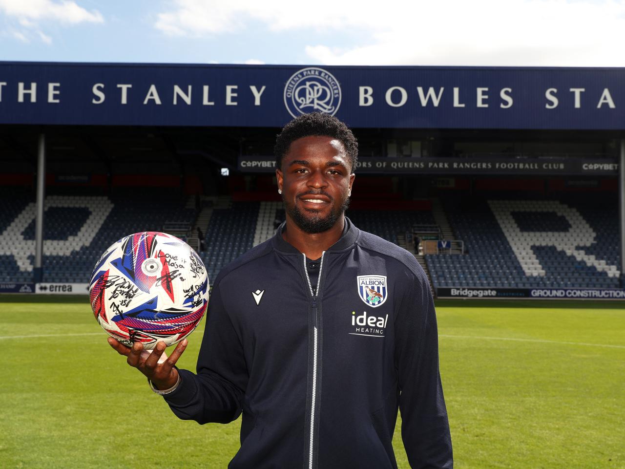 Josh Maja smiling at the camera while holding the match ball at QPR 