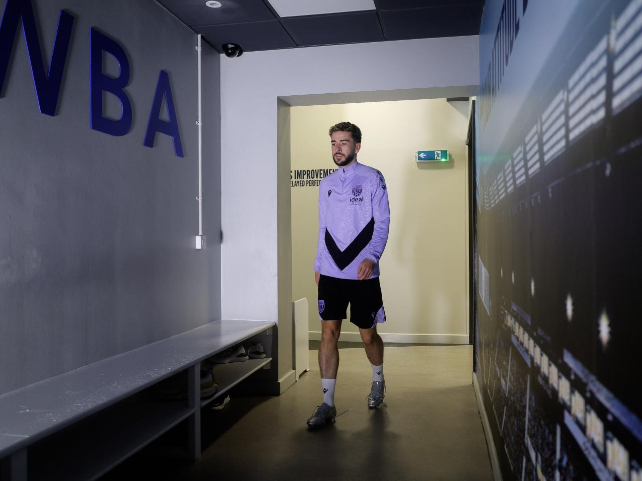 Mikey Johnston walking through a corridor at the training ground 
