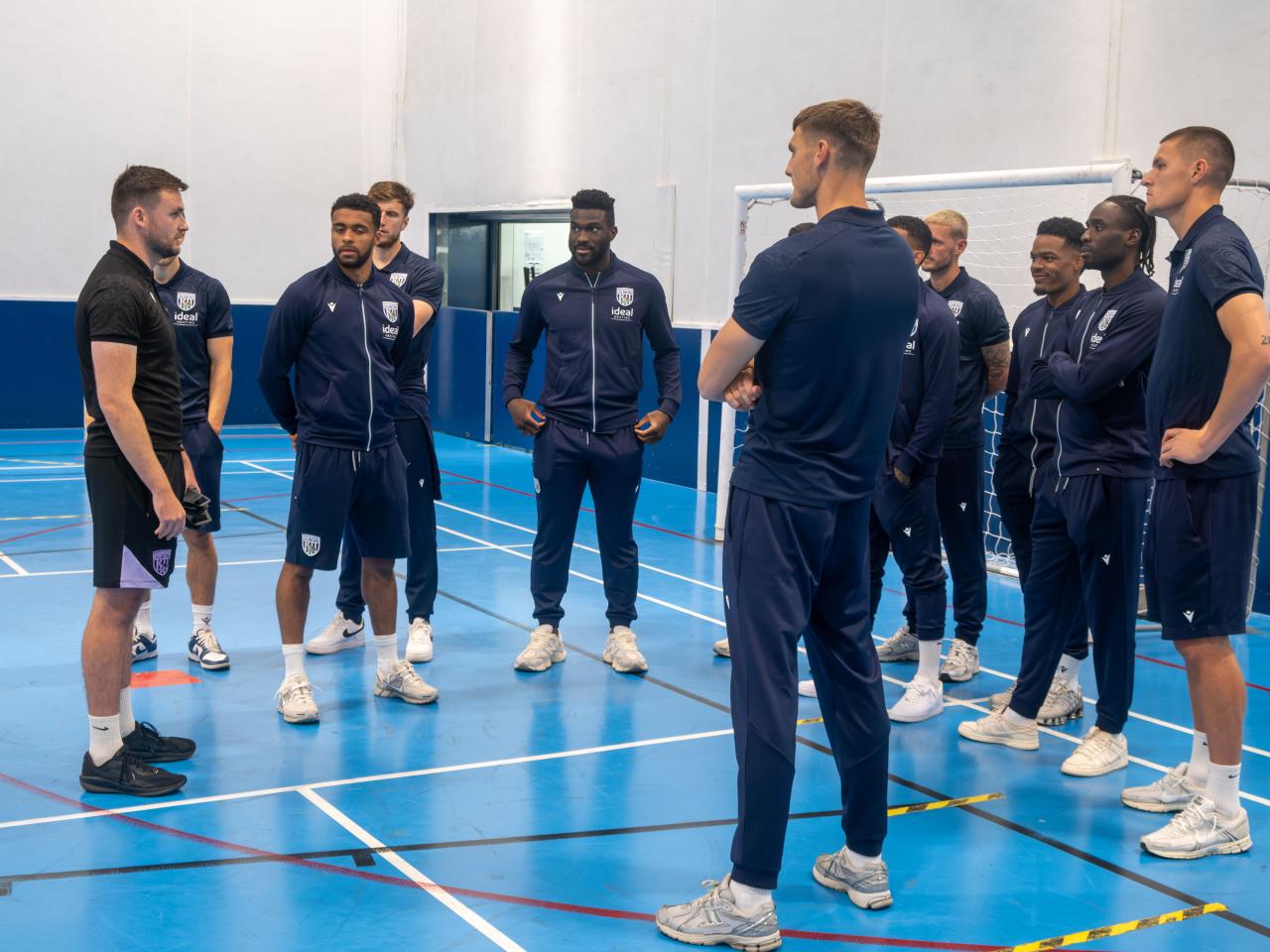 Albion first team players receive a blind football explanation from coach Rich Henderson.