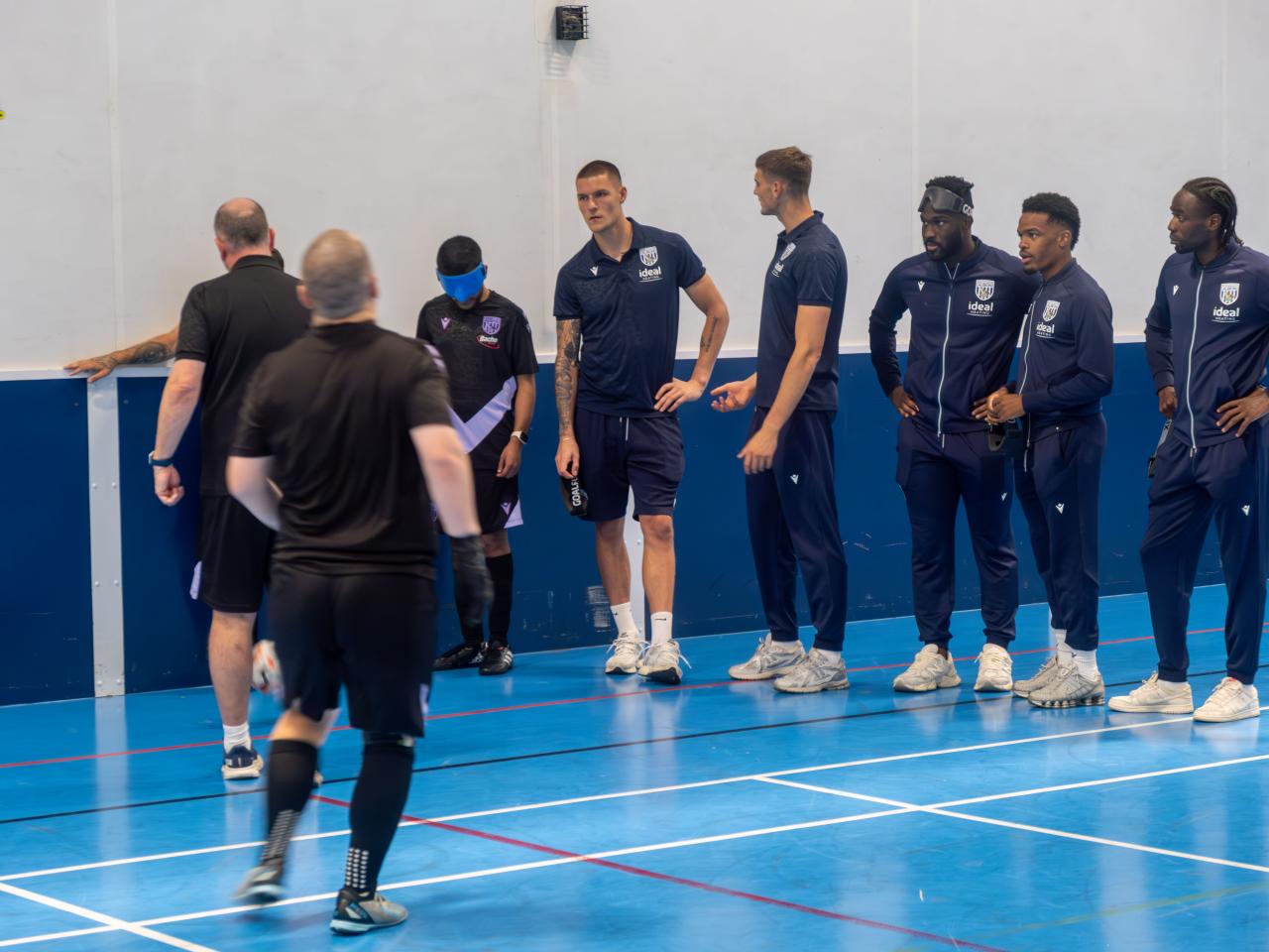 Albion first team players receive a blind football explanation.