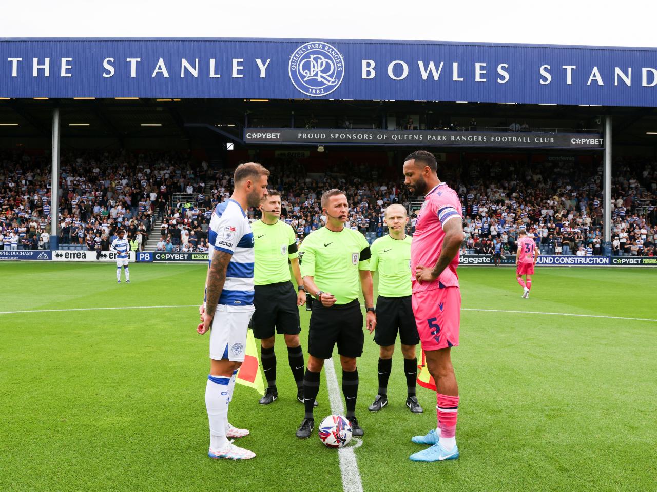 Kyle Bartley and the QPR captain line up for the coin toss on the halfway line with the officials 