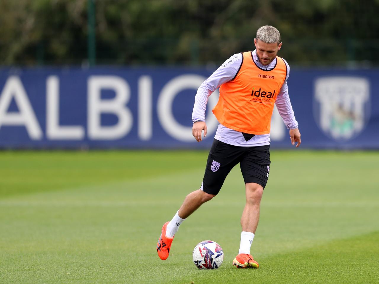 John Swift on the ball during a training session wearing an orange bib