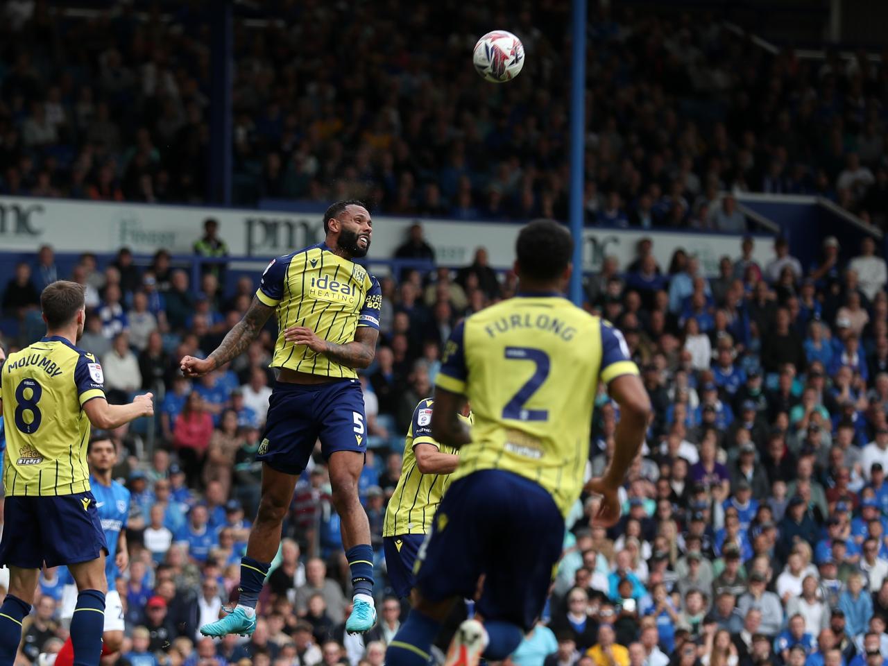 Albion in action against Portsmouth at Fratton Park, in yellow and blue away colours.