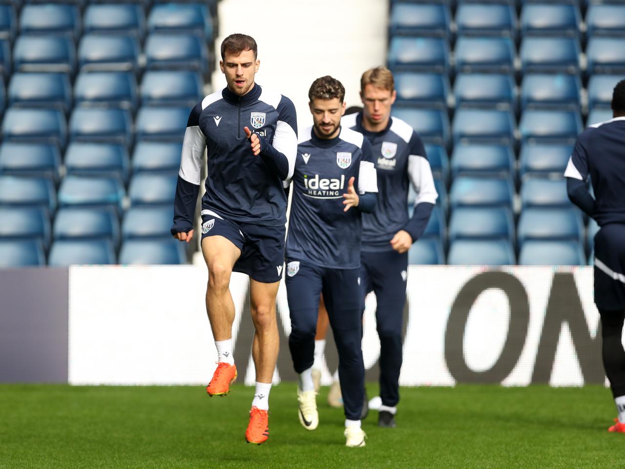 Several Albion players warming up before a training session at The Hawthorns