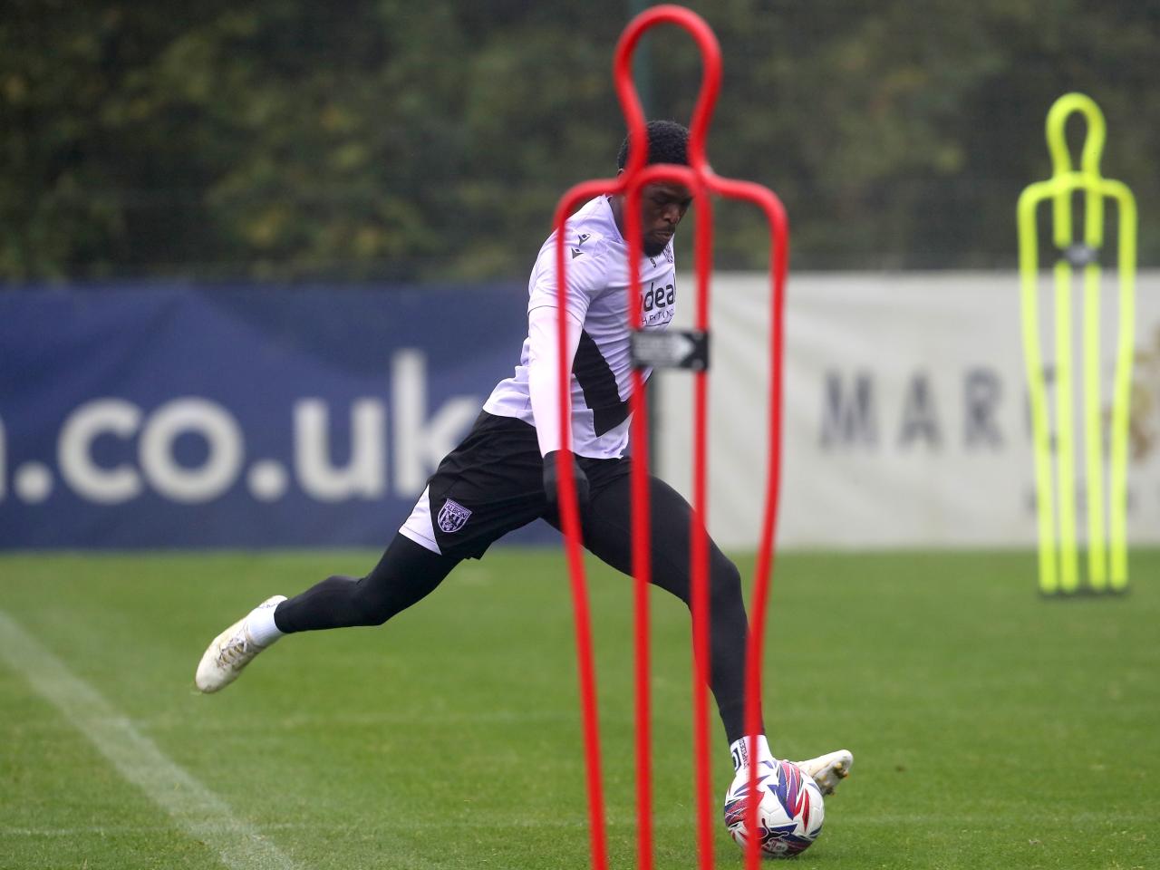 Josh Maja striking the ball behind a mannequin during a training session 