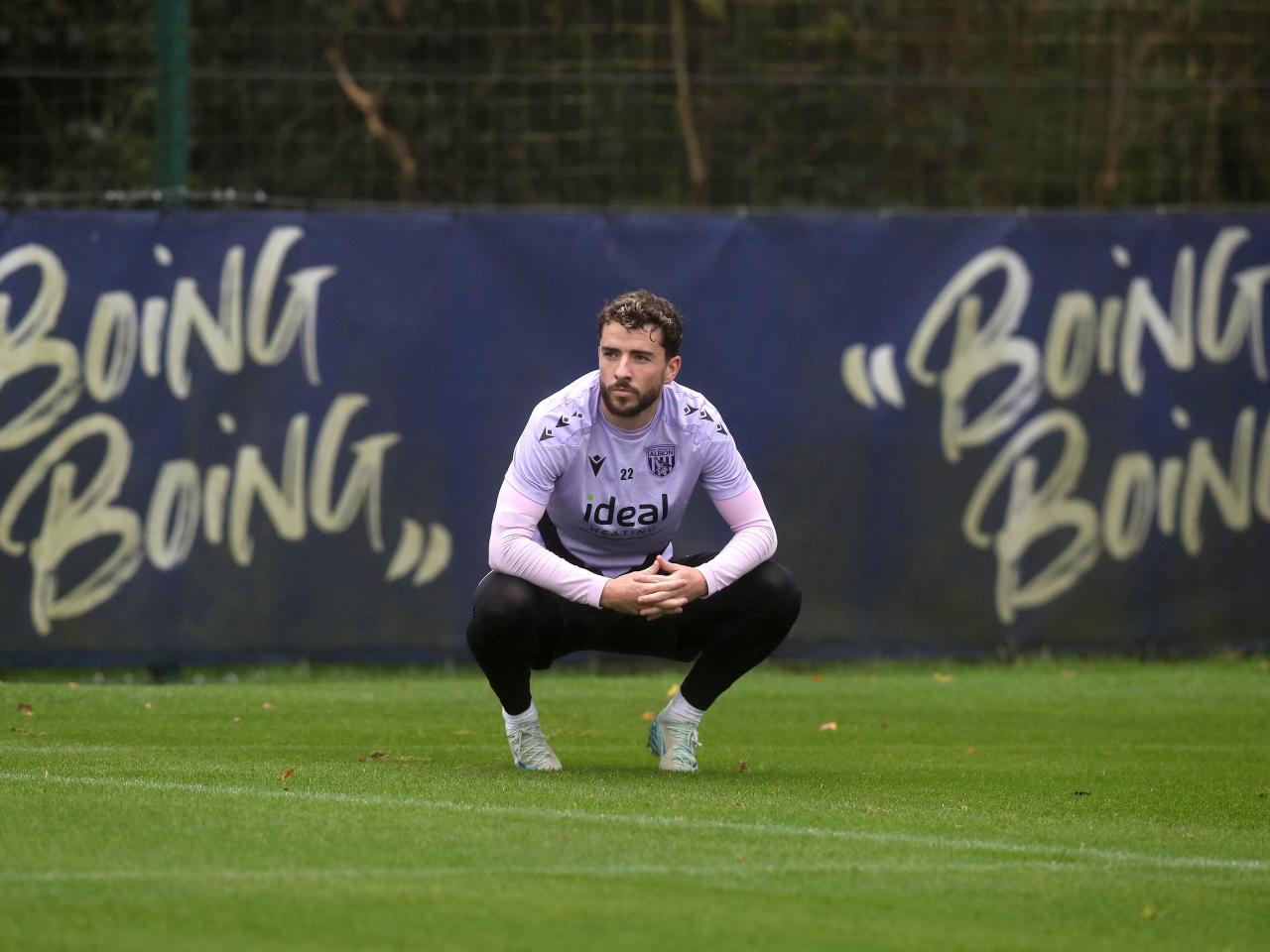 Mikey Johnston crouched down watching training 