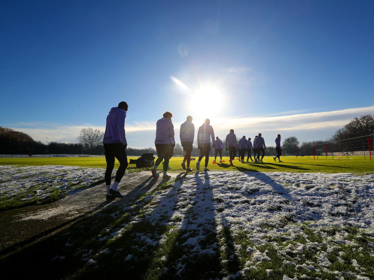 A general view of training in the sunlight with shadows on the pitch 