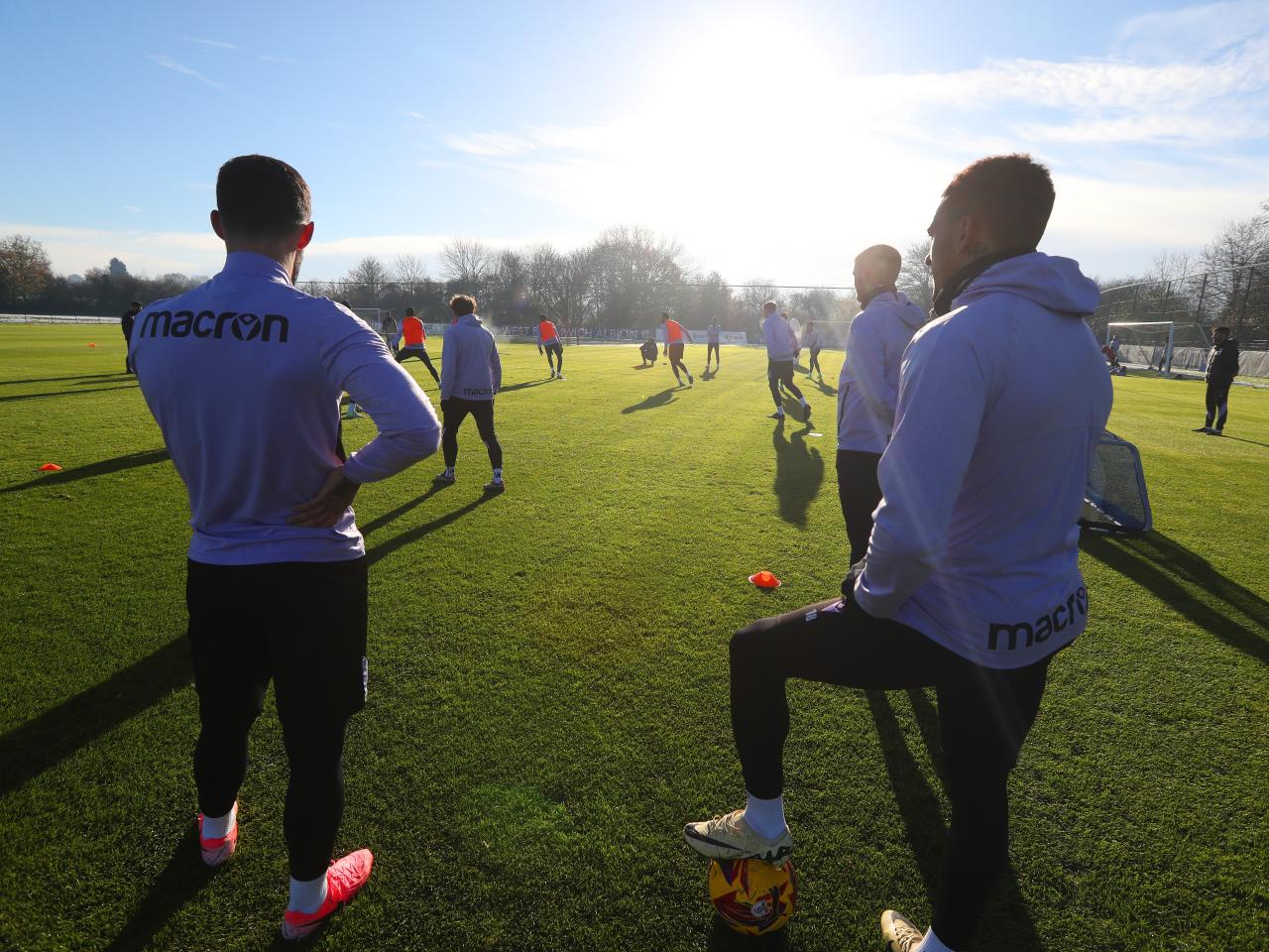 A group of players watching a training session 