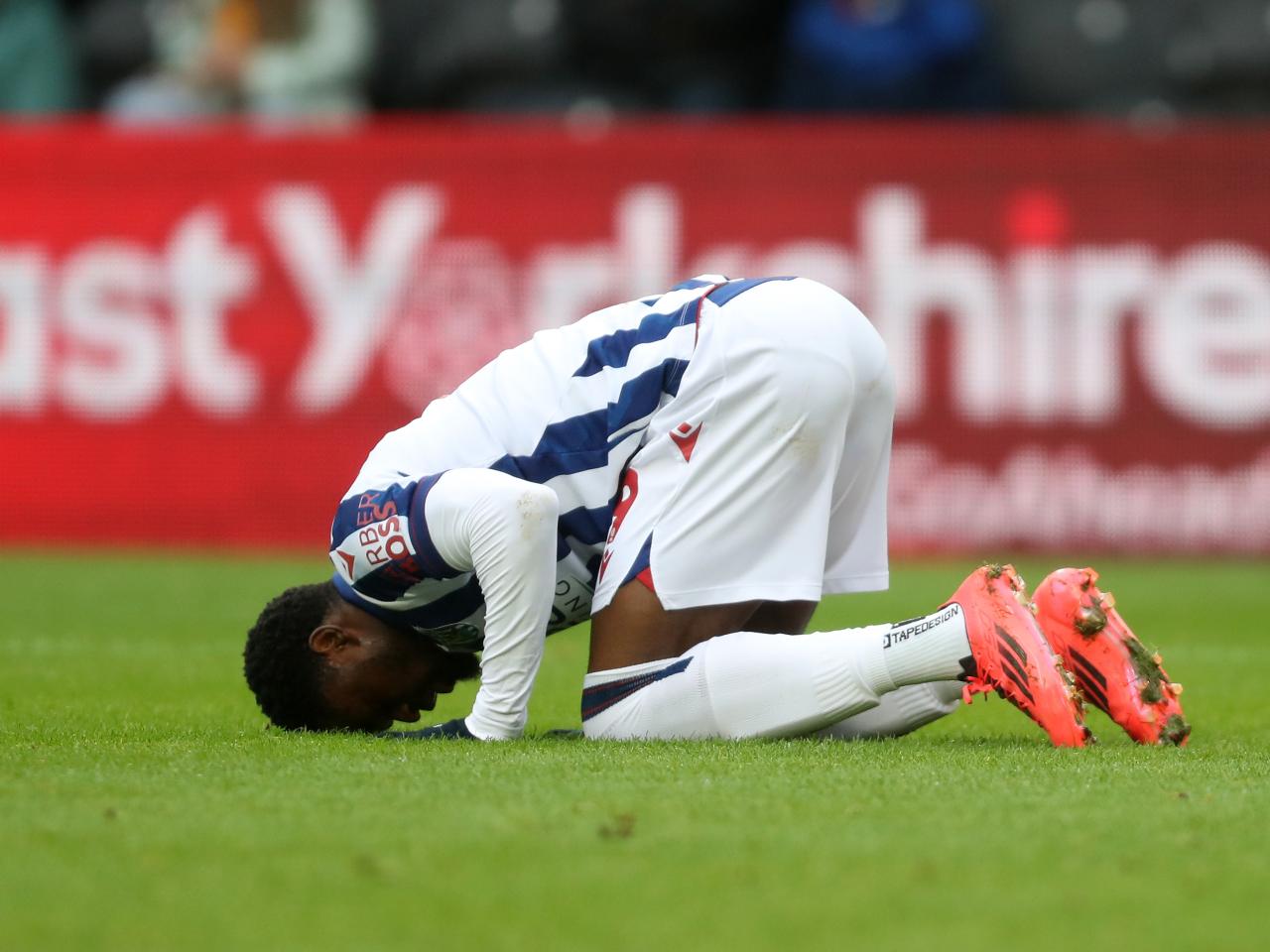 Josh Maja celebrates scoring against Hull by crouching down on the floor with his head in the grass