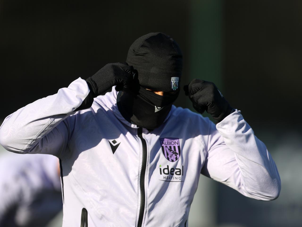 An Albion player wearing a hat and a snood during a training session