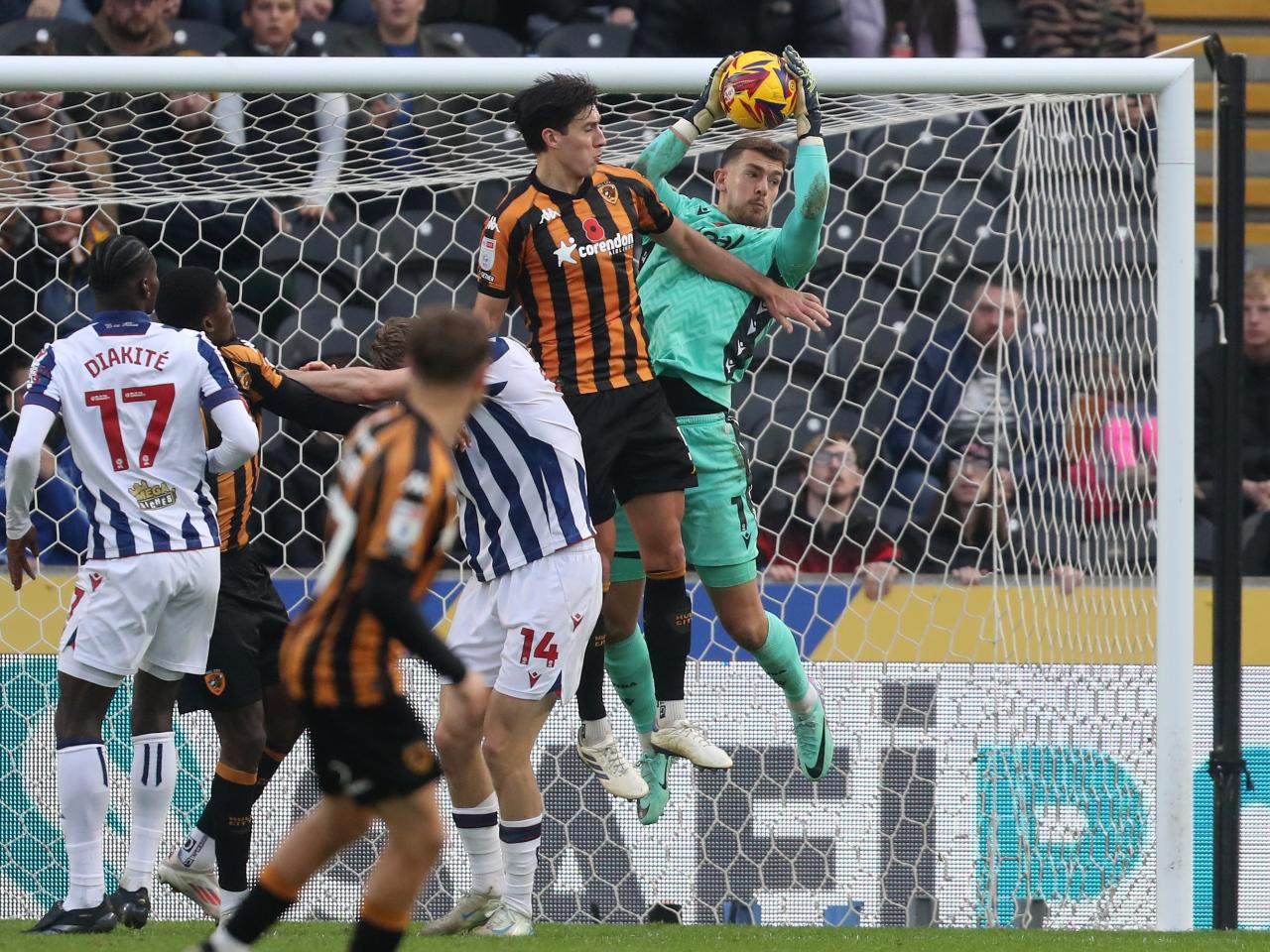 Alex Palmer jumps with a Hull player to try and win the ball