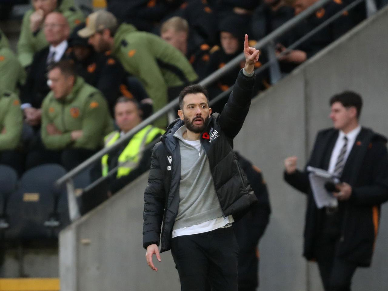 Carlos Corberán on the side of the pitch at Hull pointing up with one finger 