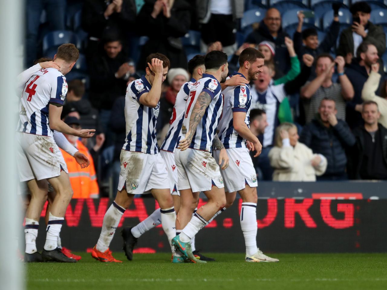 John Swift celebrates scoring against Oxford at The Hawthorns with team-mates
