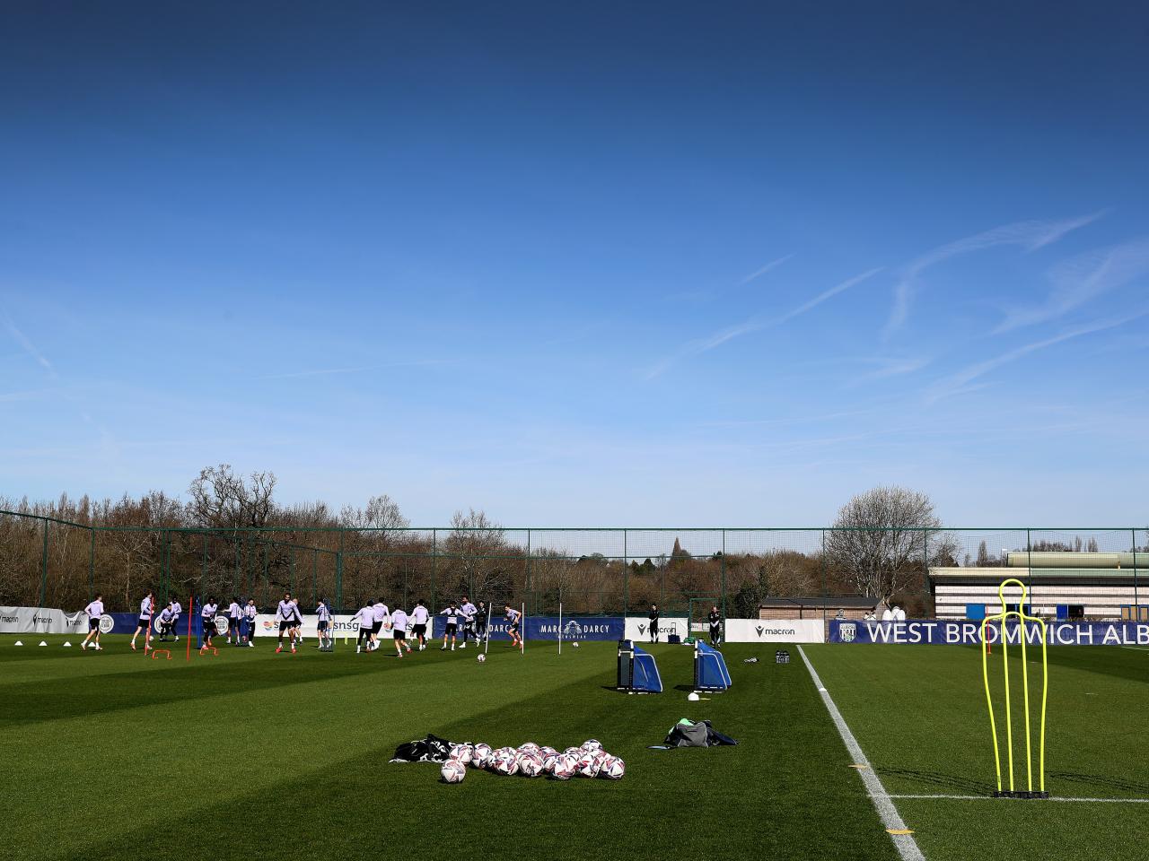 A general view of training in the sunlight with several players in shot