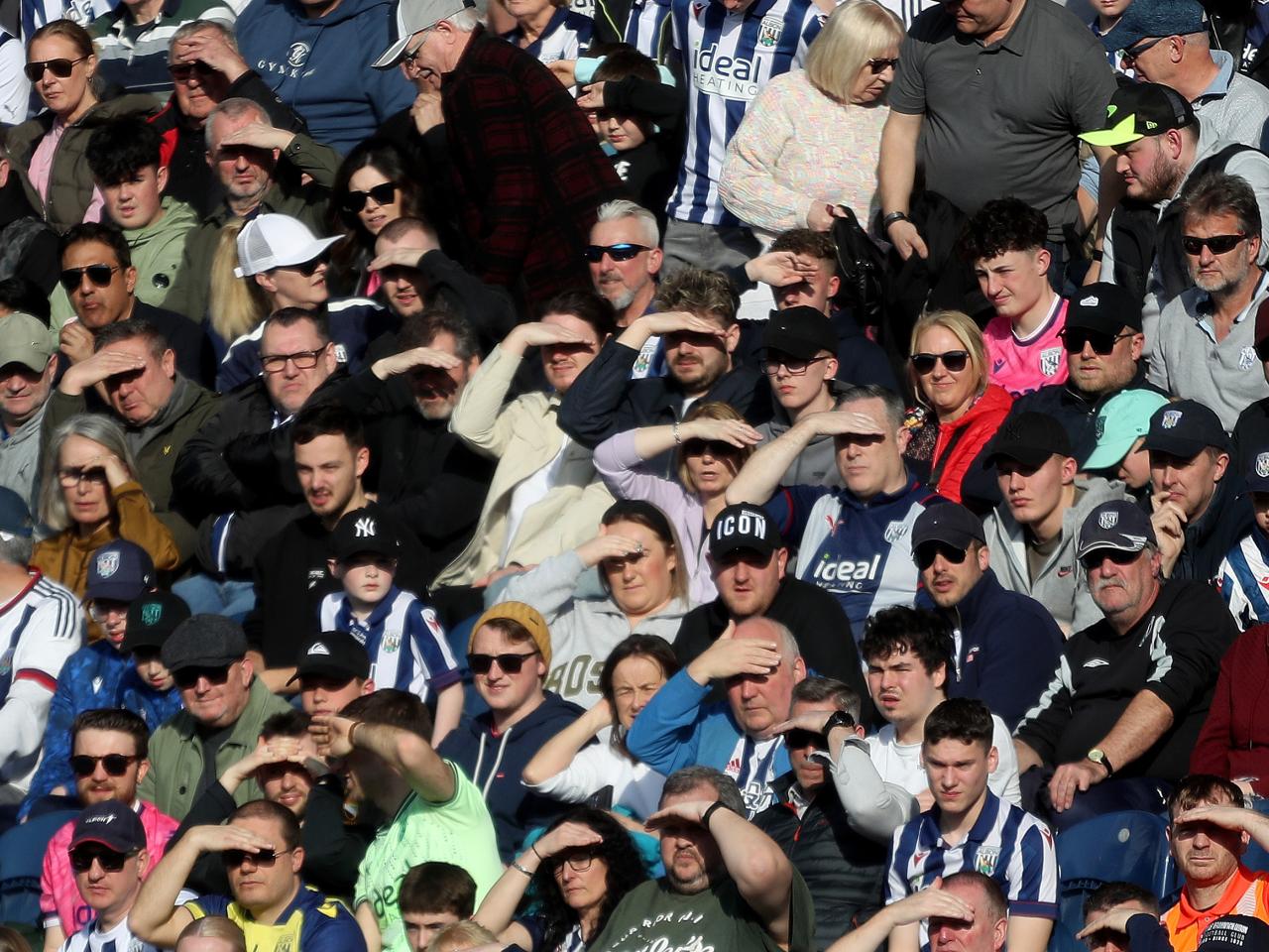 Albion fans shield their eyes from the sun in the stand at The Hawthorns 