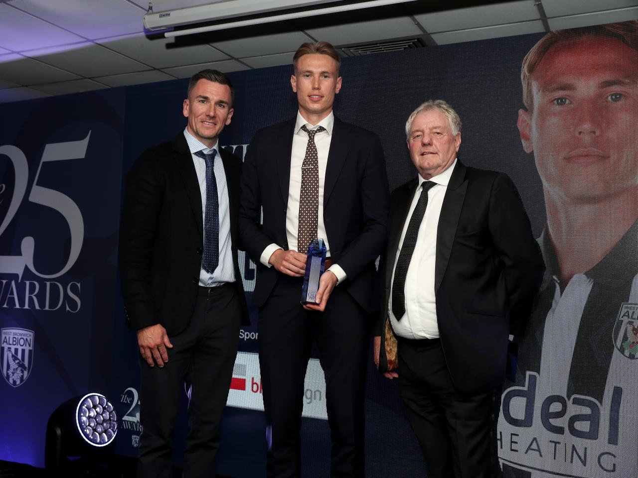 Jed Wallace and Torbjørn Heggem pose for a photo with a sponsor on stage at the end of season awards dinner