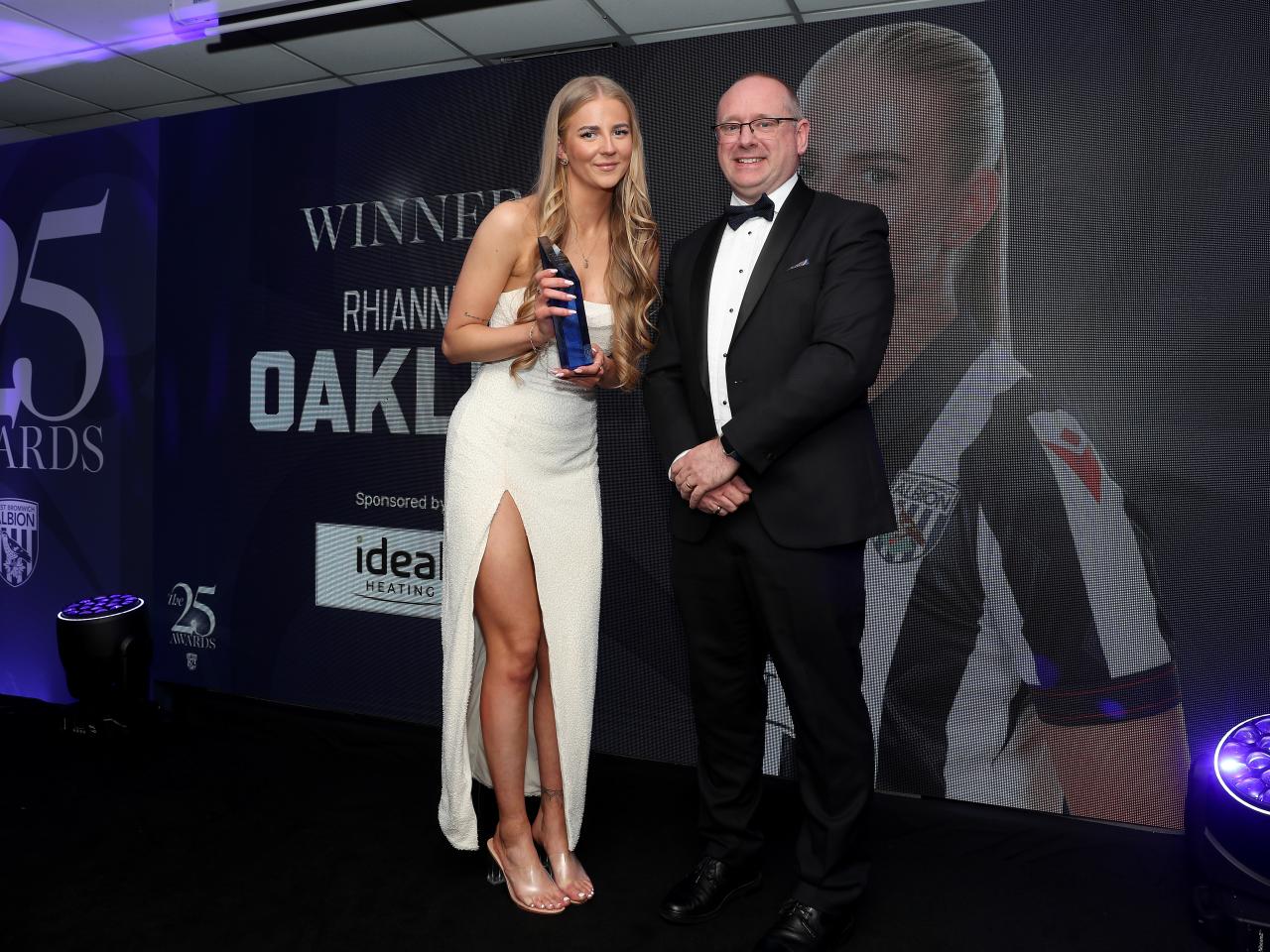 Rhianne Oakley and Mark Miles pose for a photo together on stage at the end of season awards dinner